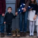 A family holding a folded American flag