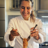 Chef Maira plating a dish of the Cleveland Clinic Approved Spaghetti & Meatballs on our 2023 Comfort Classics Menu