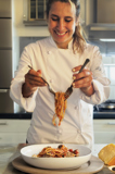 Chef Maira plating a dish of the Cleveland Clinic Approved Spaghetti & Meatballs on our 2023 Comfort Classics Menu